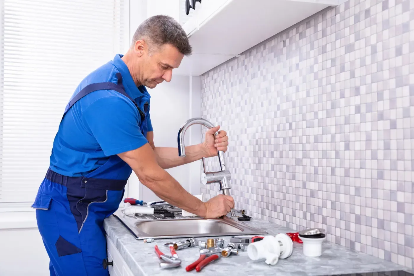 Plombier installant un mitigeur Grohe sur un évier à Antony (92160)